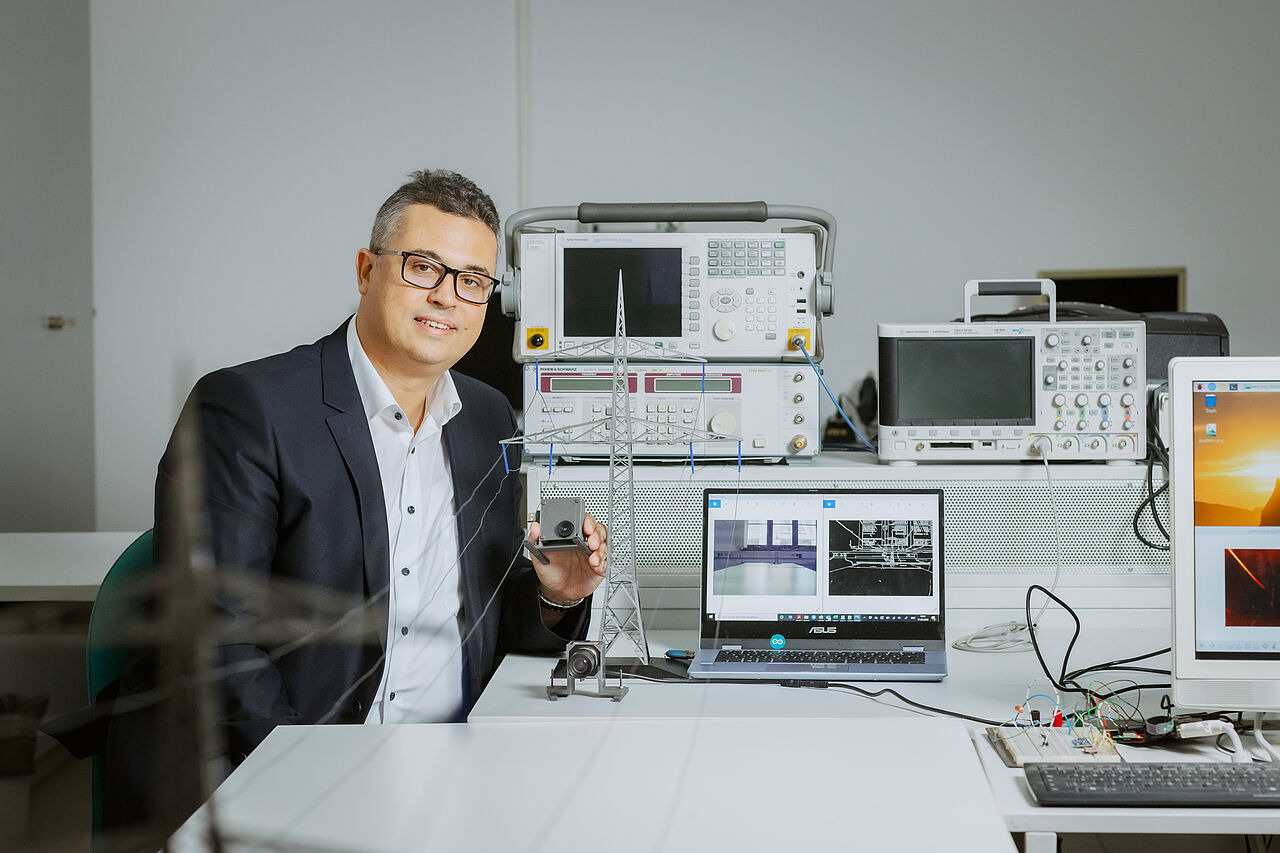 Prof. Faouzi Derbel zeigt, wie die Messeinrichtung mittels intelligenter Bildverarbeitung den maximalen Durchhang von Stromleitungen erkennen soll (Bild: Stephan Flad / HTWK Leipzig)