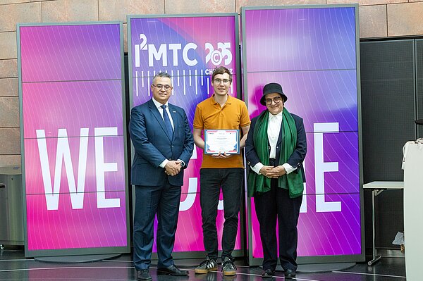 drei Personen auf einer Bühne