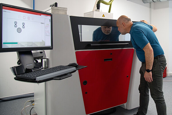 3D-Drucker ein Mann schaut in einen Drucker rein