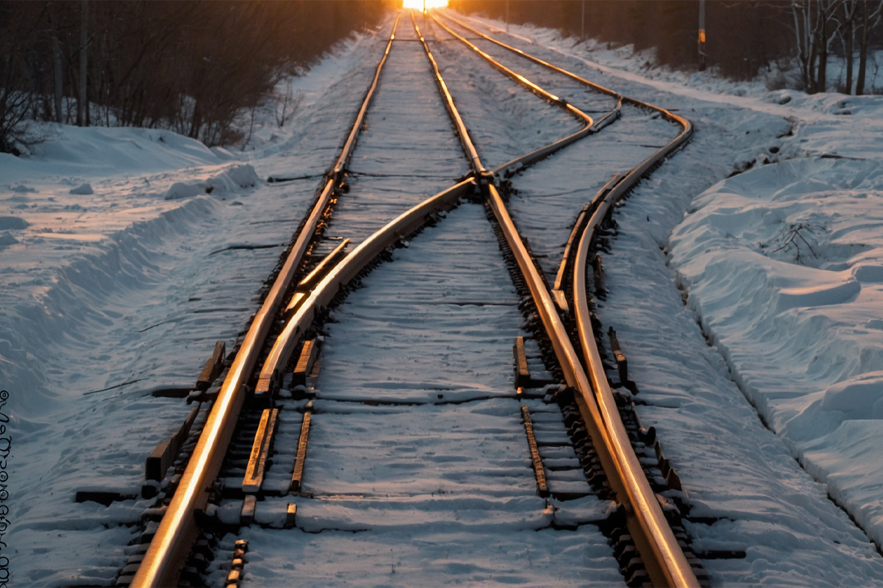 schneebedeckte Schienen, Schienennetz mit Weichen beim Sonnenuntergang/eine Verlinkung des Bildes führt zur Forschungsprojektwebsite